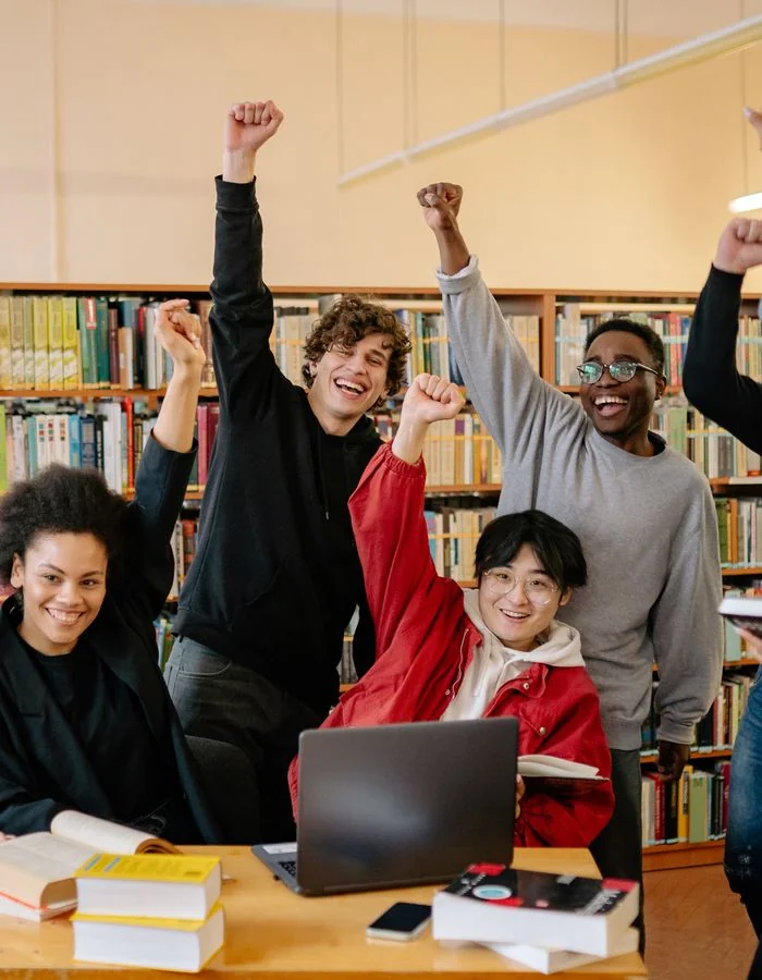 Students celebrating academic success in a library